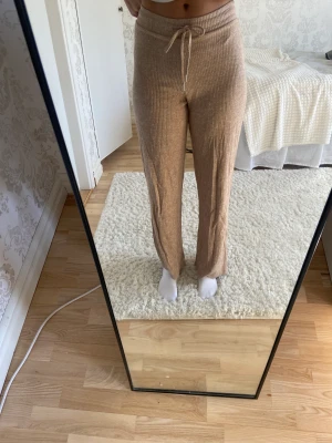 Mjukisbyxor nelly  - Säljer dessa beiga mjukisar från Nelly. Använt fåtal ggr. Storlek s och jag på bilden är 170 cm. Frakt tillkommer 🫶🏼