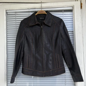 Vintage läderjacka/skinnjacka (lammskinn) lambskin - Fantastisk vintage läderjacka (äkta lammskinn) i mörkbrun färg, orangea detaljer. Strl: L, upplevs som en M. 