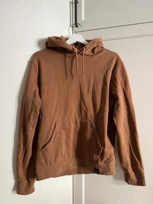 Light brown hoodie. Front pocket seam is broken (but easy to fix). Soft and thinner material. Classic fit, not oversize.