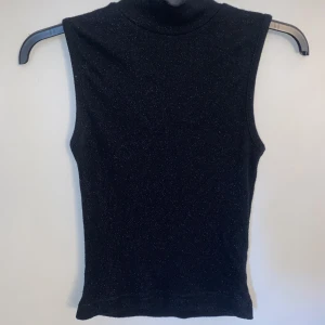 Fest topp - Jätte fin vardags och fest topp. Köpt secondhand men väldigt fin. En svart glittrig topp med halv polo. Säljer då den inte kommit till användning. Storleken är S❤️
