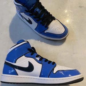 Jordan 1 mid signal blue - Jag säljer mina Jordan 1 mid signal blue för att de inte passar mig längre. Skorna är i väldigt bra skick, de är knappast använda. Köpta på footlocker  för retail. Har inte OG box och inget kvitto för dem. Kan ge mer foton. Pris kan diskuteras