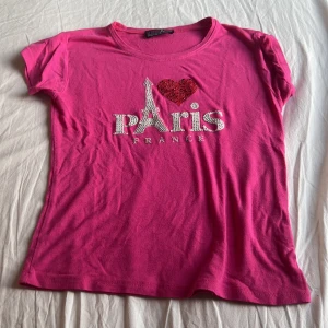 babytee  - babytee i färgen hotpink, storleken är oklar men den sitter som en babytee/magtröja men tajt på på mig som har storlek S💗 motivet är rhinestones, köpt i paris så går nog inte att få tag på!