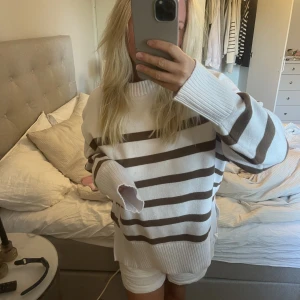 Stickad tröja - Jättemysig stickad tröja med bruna ränder, aldrig använd. Stl XL men sitter som en M ungefär (beroende på hur man vill att den ska sitta). 
