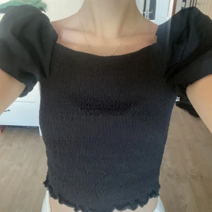 Ribbad Svart topp med puff armar - Svart ribbad topp med puff armar som passar perfekt till en fest eller vardags!