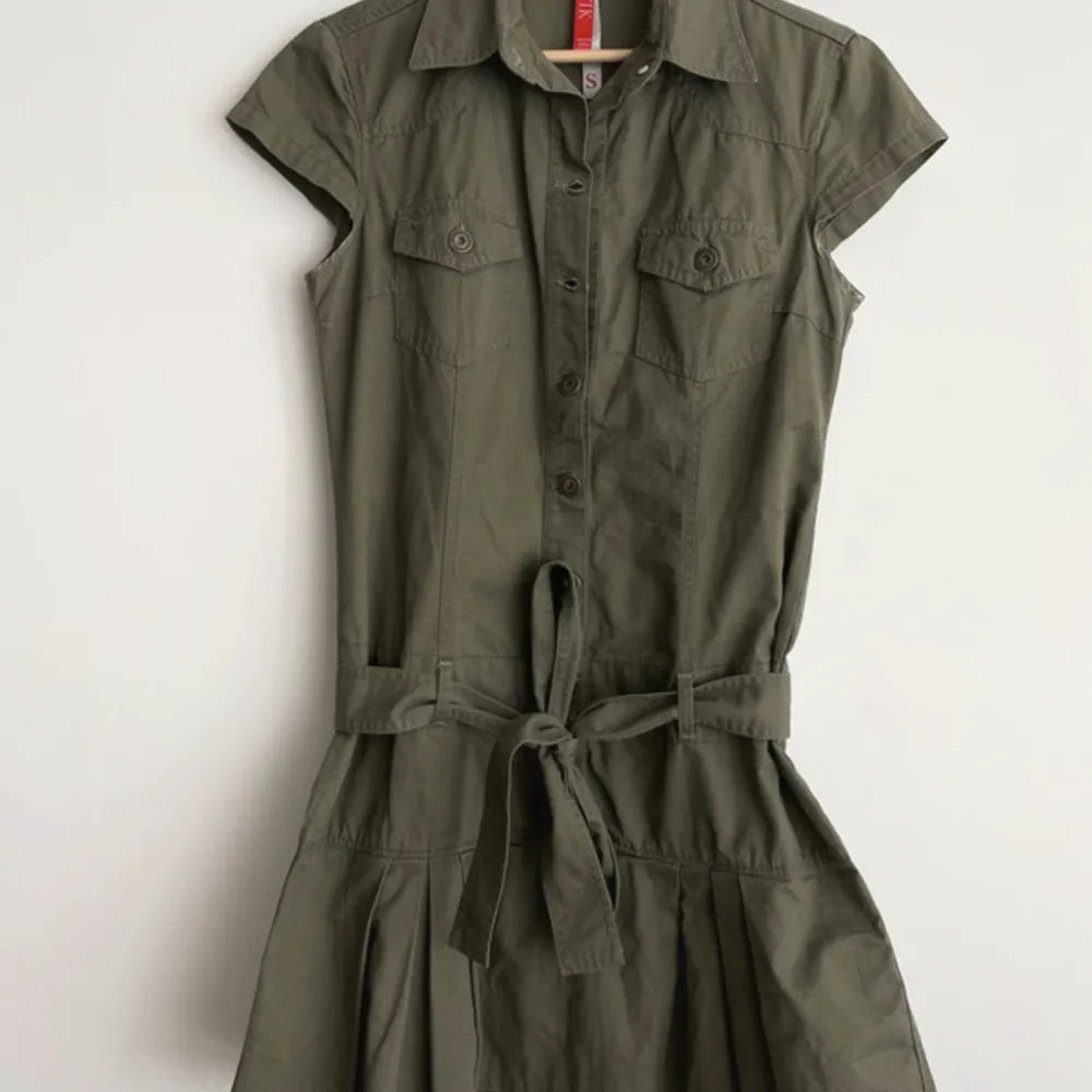 Säljer denna ursnygga olivgröna militärinspirerade klänningen med så snygga detaljer!!💖 Den passar mig som är S/M men går att justera i midjan med ett midjeband så passar nog de flesta!! Jag är 175 och den är bra i längden, men passar också korta!🌸💓. Klänningar.