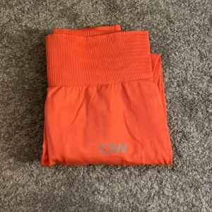 Träningstights - Röd/orange tights från icaniwill. Använda en gång. Storlek S