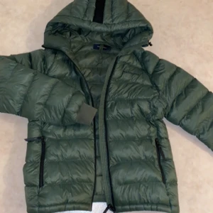 Peak performance jacka - Peak performance W TOMIC JACKET. Välvårdad jacka använd en vinter bara. Skick som om den köptes igår. Fin grön färg med svart detalj på luvan. Nypris 2599kr. Köpte den på stadium förra året. Tror ej den finns kvar. Säljer för 1500kr. 