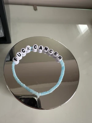 Smycken  - Säljer ett egengjort armband där det står ”fuck cancer” 🩷 