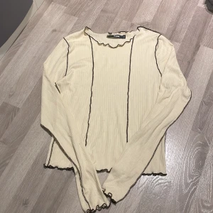 Tröja - Långarmad tunn tröja från Bikbok. Storlek M, knappast använd. Lite genomskinlig med med en beige/vit bh syns inget igenom. Räfflad och sömmar utåt vilket gör den lite extra snygg. Säljs då den knappt kommer till användning.
