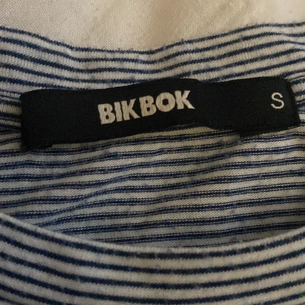 Randig Bikbok T-shirt som har en liten regnbåge på sig. Storlek s.. T-shirts.