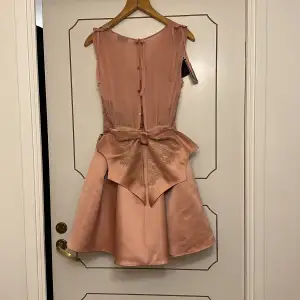 Super söt festklänning med rosett baktill. Går även att ta isär så det blir kjol och topp. Storlek 42 i barn, skulle säga den passar en 32. Aldrig använd, med prislapp på!