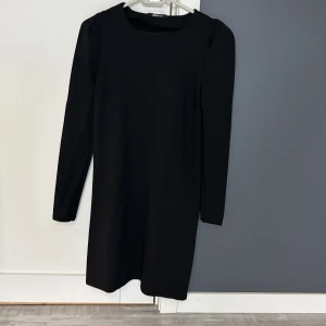 Klänning - Svart klänning från Ginat tricot använd bara en gång. Normal i storlek och i mycket bra skick! Små finns puffar armar.