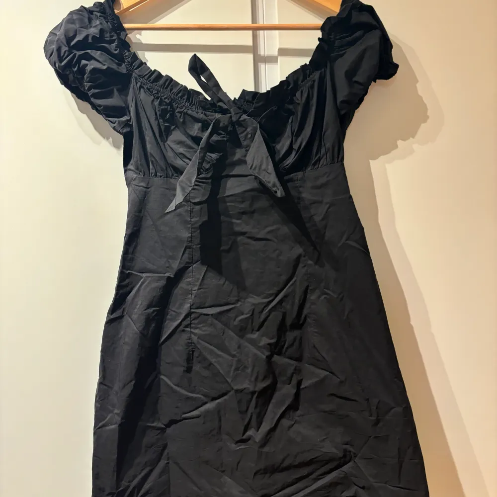 Säljer denna fina svarta klänning med knytning från Nelly. Den är storlek 38 och skulle säga att den passar en XS/S. . Klänningar.