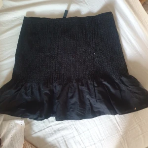 Kjol - Svart kjol med volanger längst ned. Aldrig använd bara testad. Det ska vara storlek M men jag skulle säga storlek L