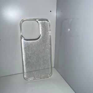 Glittrigt mobilskal  - Superfint glittrigt mobilskal som aldrig är använt, då jag har liknande. Passar till iPhone 14 Pro. Hårt skal. FRAKTEN ÄR 20KR