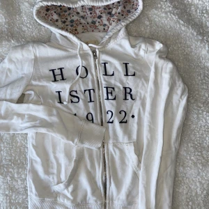 Golvlister hoodie  - Vit hoodie med blommor i luvan. 