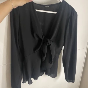 Svart blus/topp - En blus/topp man själv knyter ihop framme, liknar den från design by si❤️Öppen fram, man knyter ihop den själv. Oanvänd. storlek S, finns i röd också