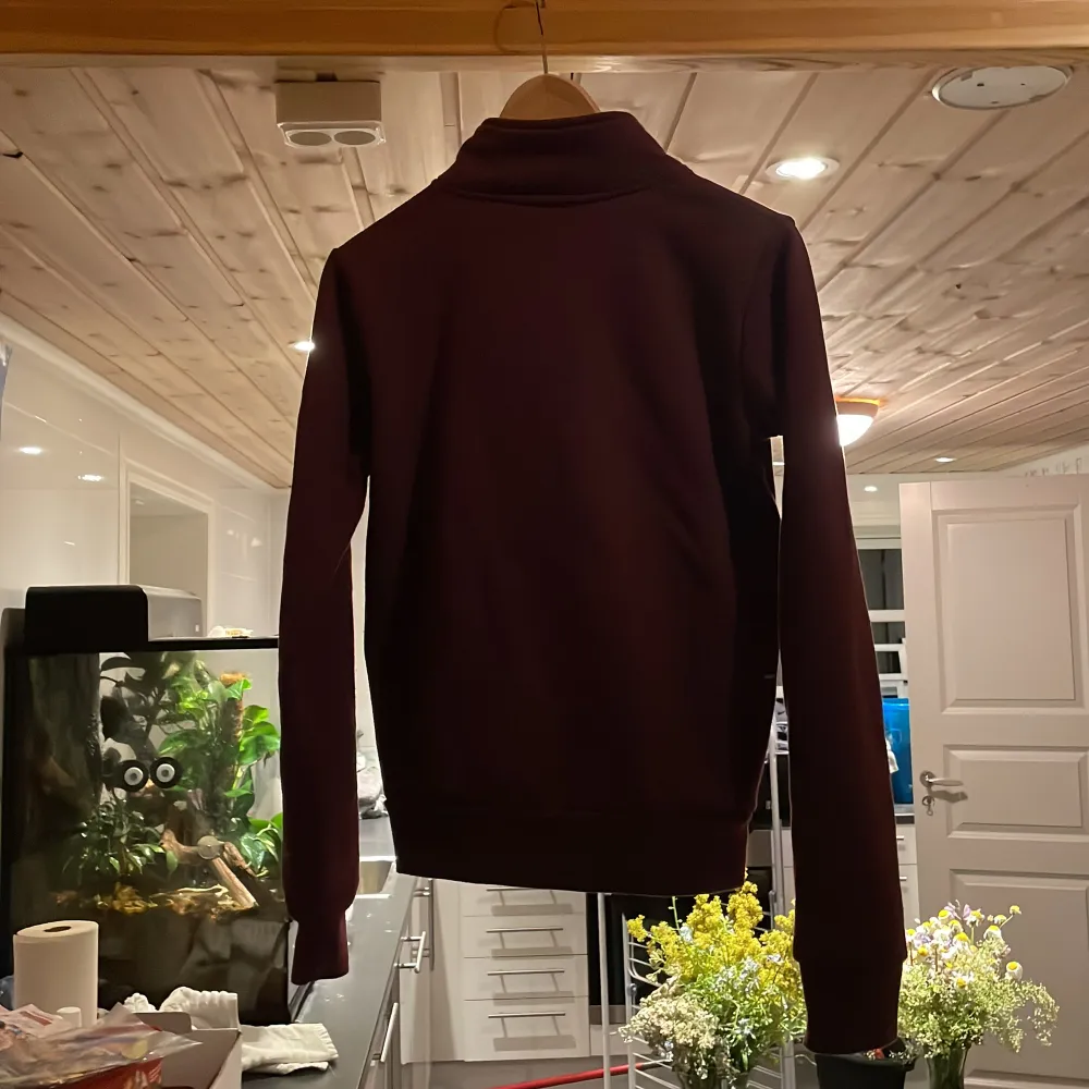 Vinröd fleece som har används i stallet, stl 170/small . Neuletakit & Villapaidat.