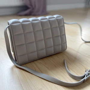 Beige axelväska - Mått; ca 24x16 cm. Köpt på hm knappt använd så nästan som ny! Jättefin inga effekter. Hör gärna av dig vid frågor, frakt ej inkl! :)