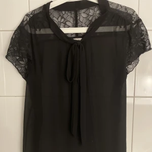 Svart spetstopp  - En supersöt svart topp med spetsdetaljer och knytning💞