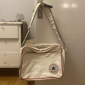 Converse väska - Jättecool converse axelremsväska. Många olika fack för tex dator. Justerbart band. Välanvänd med en del defekter men fyller sin funktion