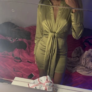 Olivgrön satin klänning  - Säljer denna snygga festklänning i materialet satin, använd få gånger.