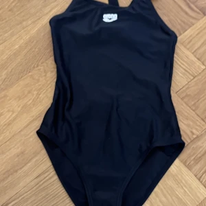 Arena baddräkt - Simbaddräkt i jättefint skick. Använts ett fåtal gånger.  58 cm från axelbandets topp till grenen. 