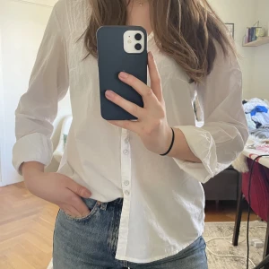 Skjorta - Vit skjorta med fina detaljer och smickrande v-ringning Hals till botten - 43 cm Bredd - 54 cm Armlängd - 61 cm