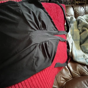 Svart topp  - En svart topp med knytband runt halsen, öppen rygg. Endast testad en gång aldrig använd. Kan skickas med frakt, Swish betalning.