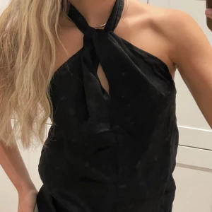 Svart topp  - Svart topp/blus med halterneck. I ett siden inspererat material. Toppen har en öppen rygg faller väldigt fint. 