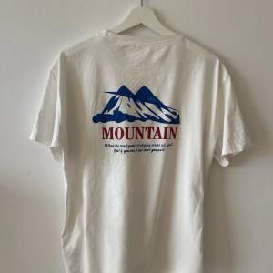 Snygg basic t-shirt med berg design. Använd fåtal gånger dock finns vissa fläckar som it gått bort men syns knappt. 