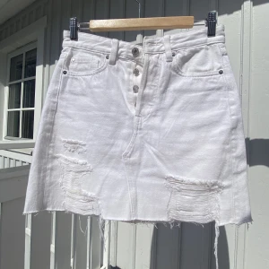 Vit Jeans Kjol med Hål 🤍⚡️ - Jättetrendig vit jeanskjol. Perfekt till vår och sommar!🌟🌸Jättebra skick. Supersnygg o slutsåld. Finns inte att köpa i Butik längre. Storlek 36.