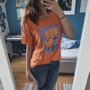Orange t-shirt med blommor på