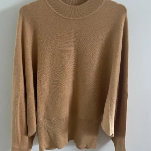 Stickad tröja från Gina Tricot  - Finstickad tröja med fladdermusärm. Tröjan är tightare över höfterna vilket ger den en snygg passform. 