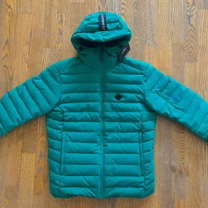 J. Lindeberg THERMIC DOWN JACKET (stlk M) - Helt ny, inga fel, snäppet grönare än vad som syns på bilden. Väldigt varm.  J. Lindeberg THERMIC DOWN JACKET. (Skidjacka) -original pris 4500kr      (Jag som har på mig jackan är 194 cm i storlek M) 