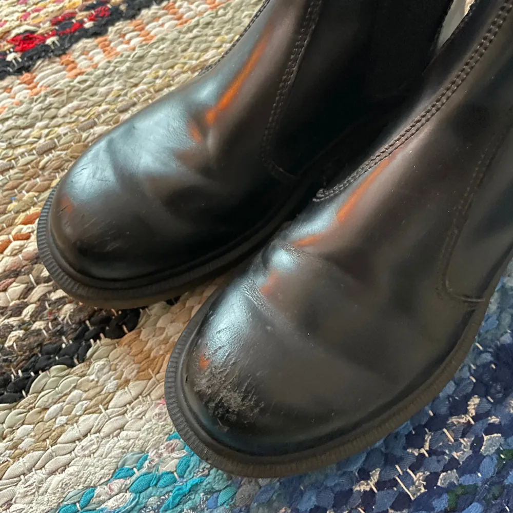 Chelsea boots från Dr Martens i svart läder. I använt skick, se slitningar på bild 2. Nypris runt 2000. Skor.