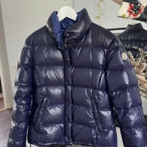 Moncler jacka dam  - Moncler Jacka i modellen Clairy i storlek 2 säljes. Koden i jackan på bild två visar att jackan är äkta eftersom att den stämmer överens med koden och modellen på bild 3 på monclers hemsida. 