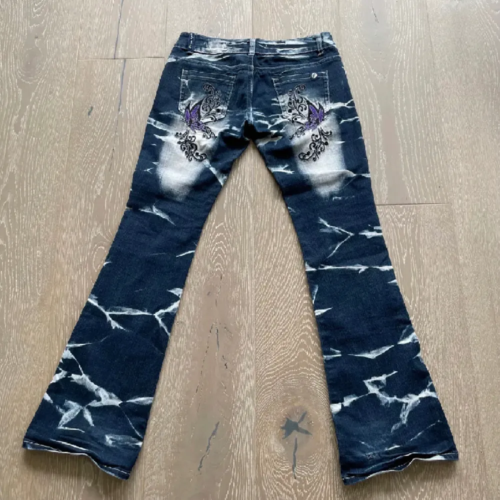 Snygga lågmidjade bootcut jeans från Crazy age med strass och tryck!! 2 fjärilar på baksidan och sex mindre på framsidan. Super bra skick förutom två nästan osynliga fläckar på framsidan ( se bild 1 ). Storlek EU 38, MÅTT - Midja-76cm, innerbenslängd-83cm. Jeans & Byxor.