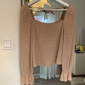 Topp  - Superfin topp med squere urringning i fram och bak. Knyt längst nacken, ”våfflat” material. Oanvänd. 