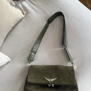 Zadig - Zadigväska i modell Rocky. Väskan är i mockamaterial. Har aldrig fått användning för den och den är därför i toppskick! Köpt för 4500, säljer för 1500