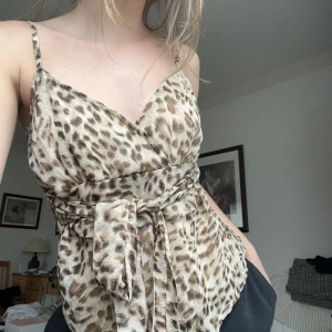 Leopard linne - Super fint linne från Vero Moda i storlek M. Den har ett beiget stretchigt innertyg, band att knyta som man vill, både till fram o bak, två knappar i ryggen och axelbanden går att ändra.🤎🤍 