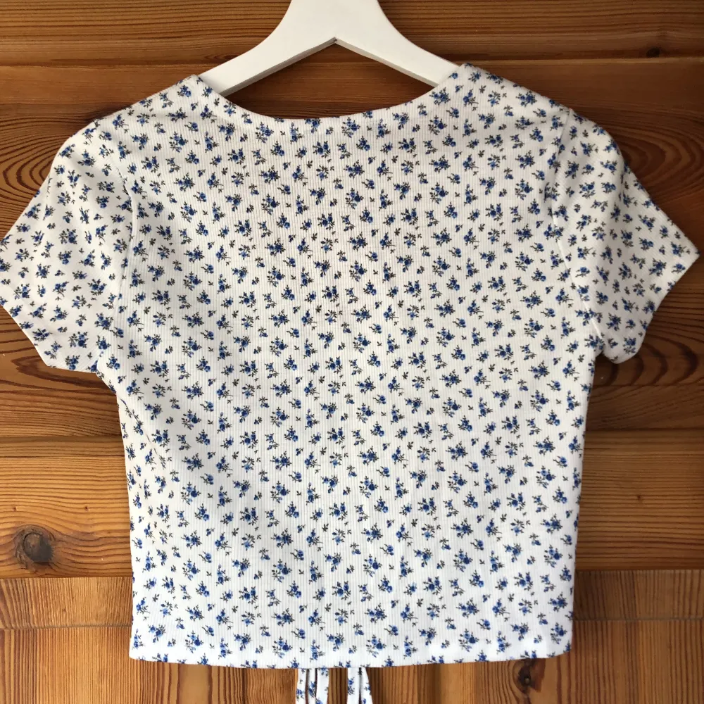 Sommar t-shirt med thight passform med små blåa blommor. Sparsamt använd, säljs då den inte kommer till användning. Frakten ingår i priset💛. Toppar.