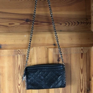 Svart axelremsväska  - Svart axelremsväska med kedjeband. Använd men i fint skick.  Frakten ingår i priset 💚