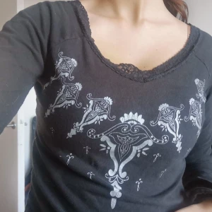 2000s tröja - Snygg 2000s svart tröja med grå tryck på armarna och byst. Väldigt bra skick. 