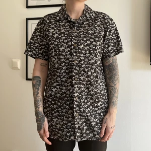 Skjorta med palmer - Kortärmad skjorta med små vita palmer på. Jag är 160 cm lång