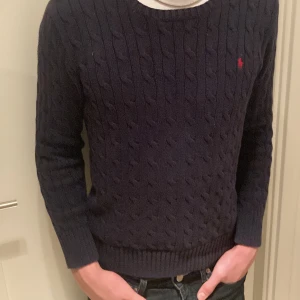 Kabelstickad raplh lauren - En super snygg kabelstickad tröja från Ralph lauren. Den börjar bli lite liten på mig och jag är ca 178 och väger 69 kilo.