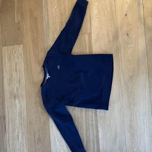 Lacostetröja  - Fin collegetröja i märket Lacoste.