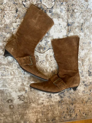 Boots med spänne - Coola boots med spänne över skon och låg klack. I bra skick, går upp till mitten av vaden ungefär 
