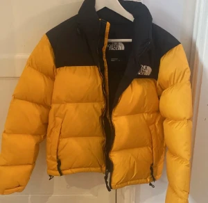 North face jacka - En North face 1996 retro jacka i färgen gul. Jackan har inga hål eller liknade och är i fint skick. Jackan är unisex. Jackan är i storlek S