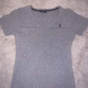 Säljer denna gråa V ringade  Ralph Lauren t-shirten som inte kommer till användning längre. Inga defekter och är i storlek S men passar även som xs!!🥰 